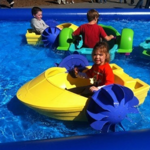 Kids enjoying water boating activity in inflatable pool ride