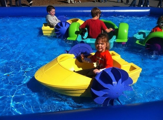 Kids enjoying water boating activity in inflatable pool ride