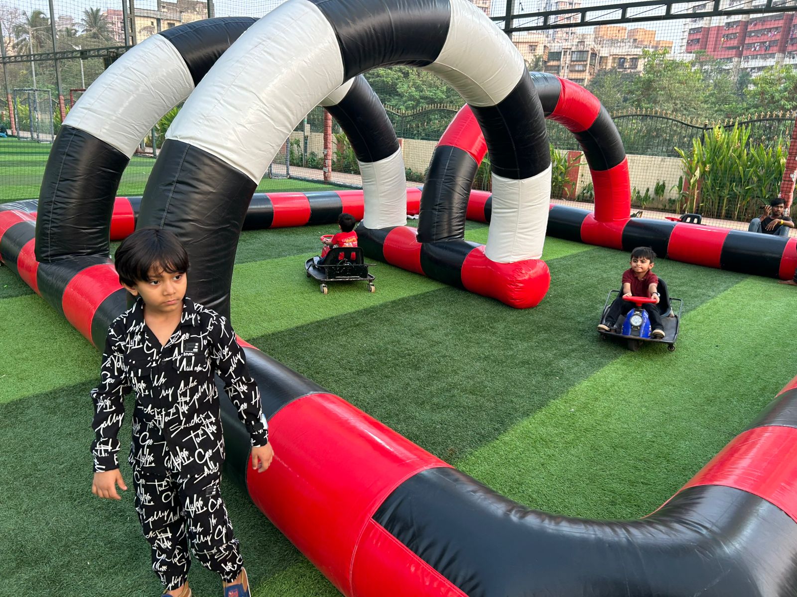 Kids riding mini go-kart cars on inflatable race track at event