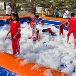 Foam party setup with kids playing in inflatable pool at outdoor event