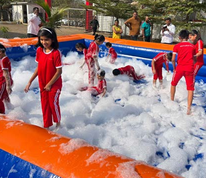 Foam party setup with kids playing in inflatable pool at outdoor event